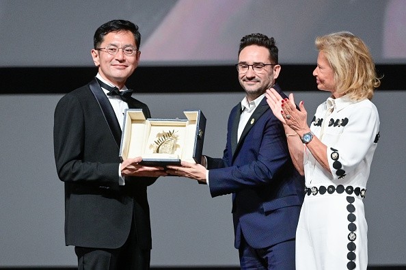 Goro Miyazaki of Studio Ghibli, who received the Honorary Palme d'Or at the 77th Cannes Film Festival, with presenter Juan Antonio Bayona (film director). Photo by: Stephane Cardinale - Corbis/Getty