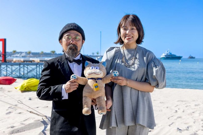 "Ghost Cat Anzu," officially screened at the 77th Cannes Film Festival's Directors' Fortnight, Directors Atsuhiro Yamashita and Haruko Kuno at the Cannes beach for a commemorative photo (C) KAZUKO WAKAYAMA